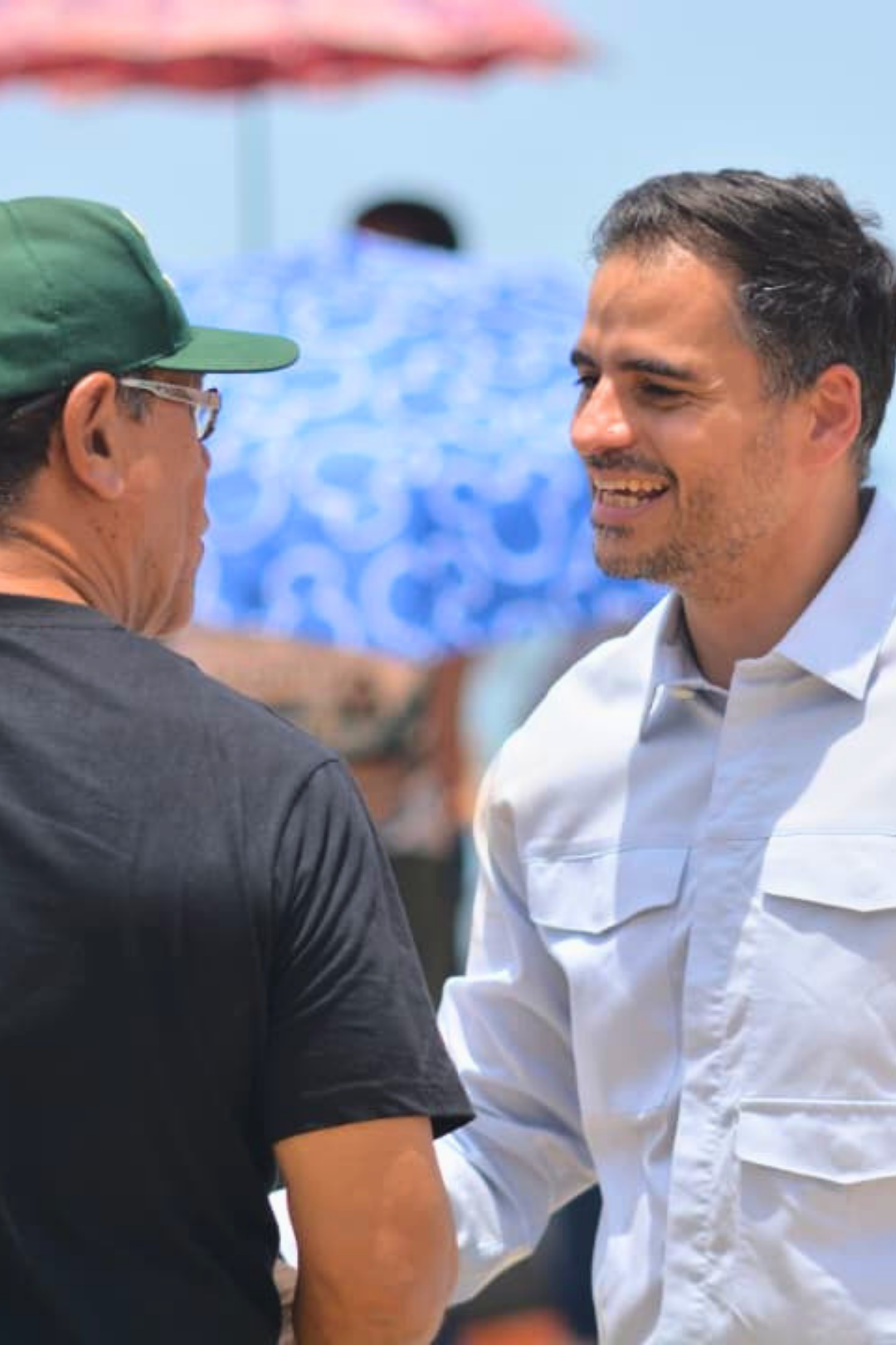Armando Armas conversando con un ciudadano durante una actividad al aire libre.